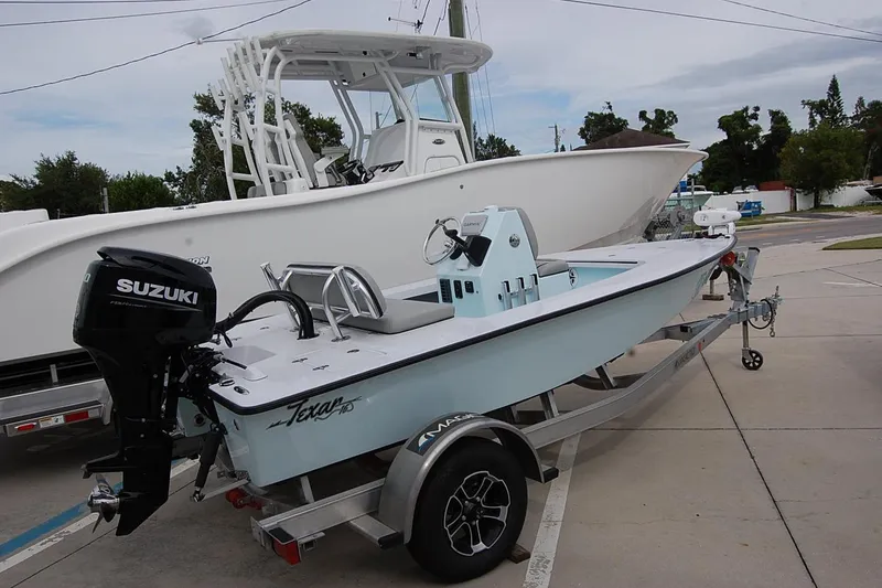 The Image of 2026 TEXAR 16 boat with Suzuki engine on trailer, parked outdoors. - 1