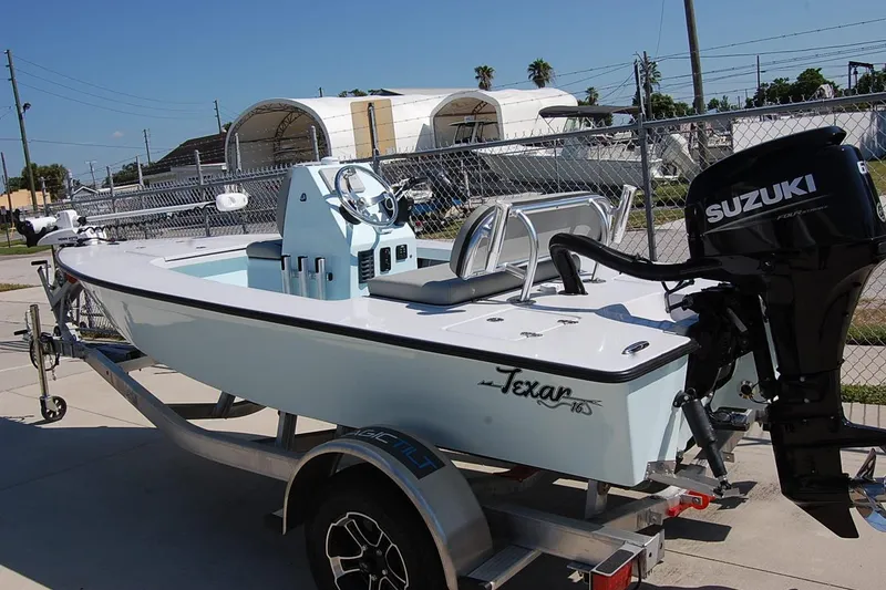 Slide: The Image of Small TEXAR 16 boat with Suzuki engine on a trailer, 2026 model. - 16