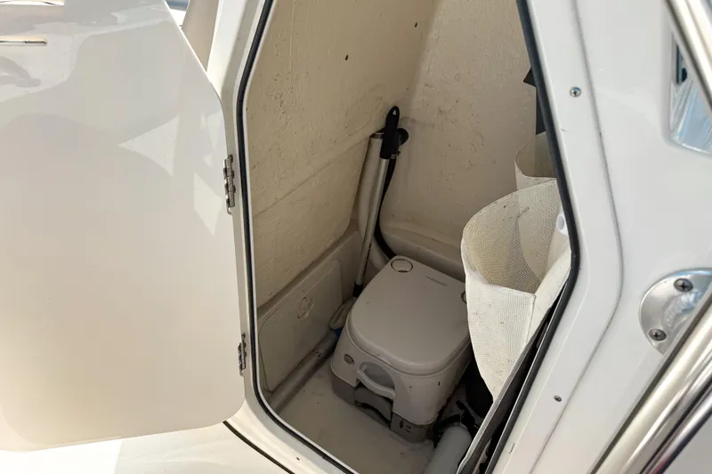 Slide: The Image of 2021 Key West 203 FS boat interior with portable toilet and storage compartment. - 13