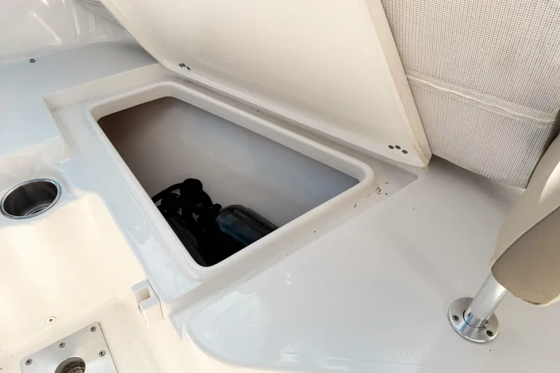 Slide: The Image of Storage compartment on 2021 Key West 203 FS boat, featuring cup holder and seat. - 18
