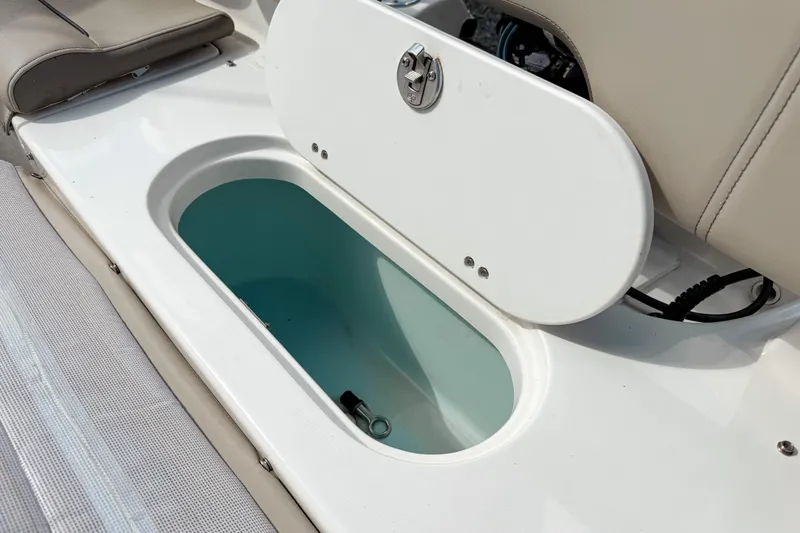 Slide: The Image of 2021 Key West 203 FS boat storage compartment with open lid, showcasing interior space. - 20