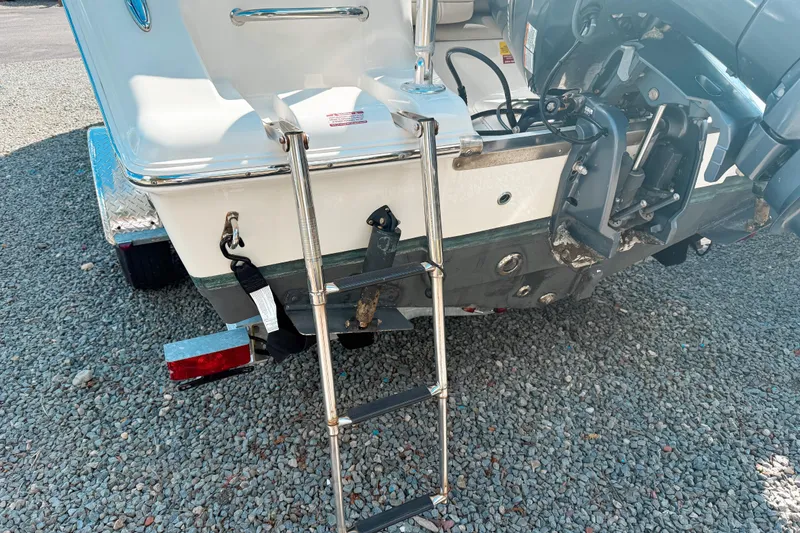 Slide: The Image of 2021 Key West 203 FS boat with ladder and motor on gravel surface. - 4