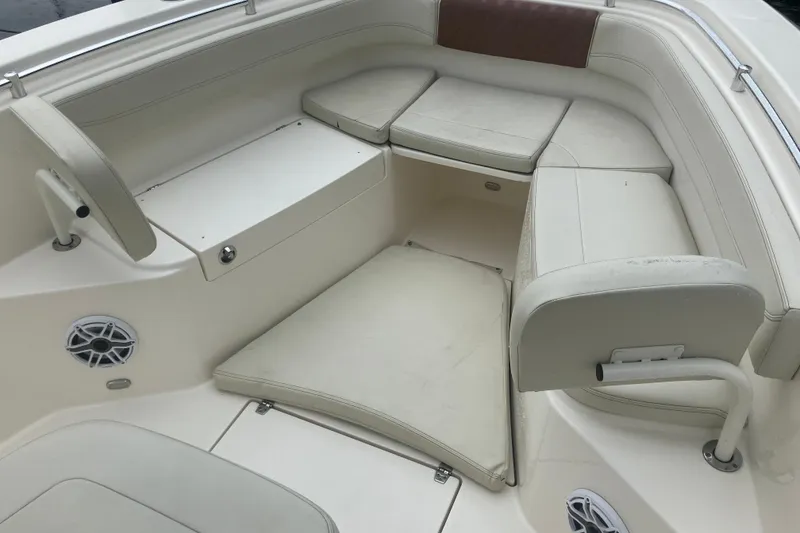 Slide: The Image of 2024 Cobia 280 Center Console boat interior with cushioned seating and speakers. - 10