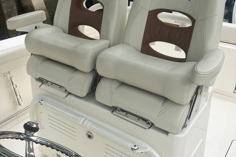 Slide: The Image of 2024 Cobia 280 Center Console boat seats with plush white upholstery and armrests. - 16