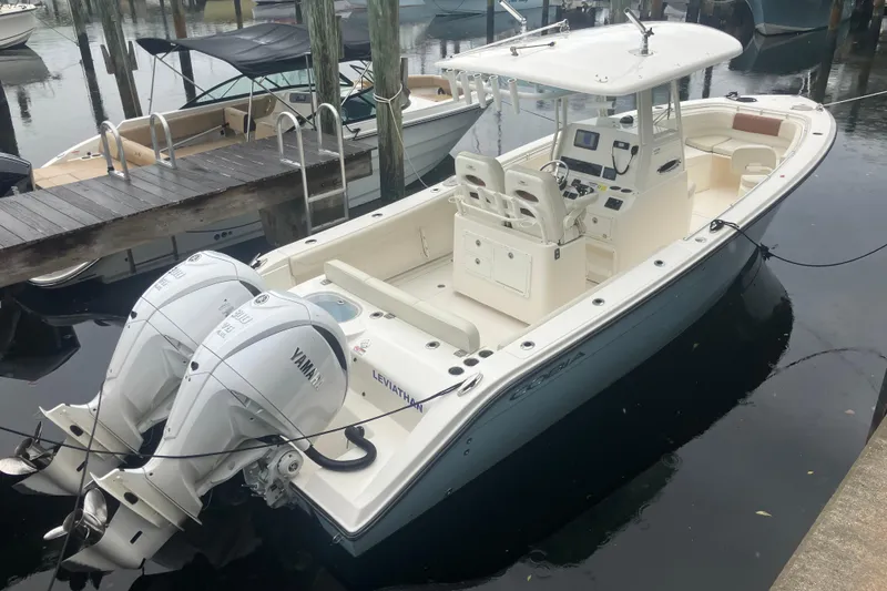 Slide: The Image of 2024 Cobia 280 Center Console boat docked with twin Yamaha engines. - 4