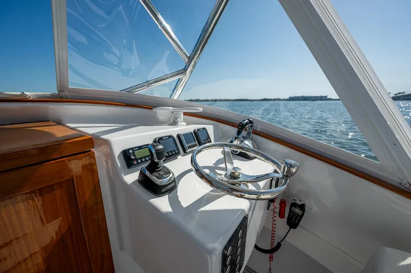 Slide: The Image of 2019 Custom Carolina Custom Express boat helm with steering wheel and navigation controls. - 11
