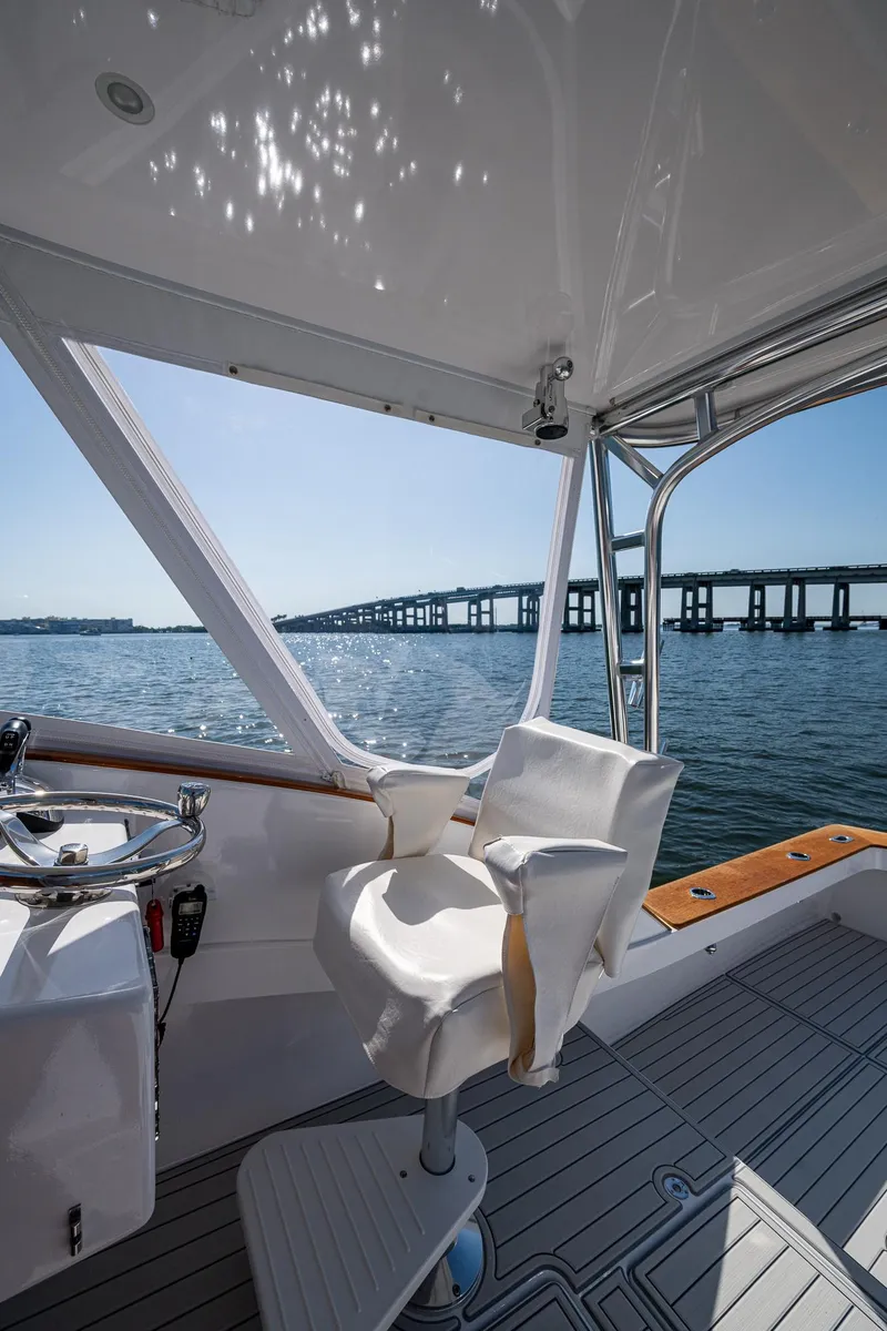 Slide: The Image of 2019 Custom Carolina Custom Express boat interior with scenic bridge view. - 15