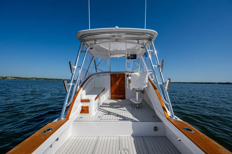 Slide: The Image of 2019 Custom Carolina Custom Express boat on open water, showcasing sleek design and spacious deck. - 18
