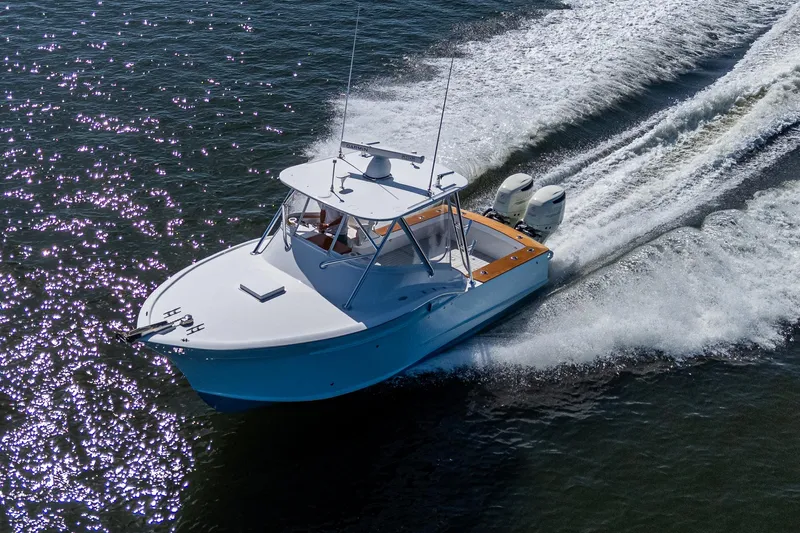 Slide: The Image of 2019 Custom Carolina Custom Express boat cruising on open water, creating a dynamic wake. - 2