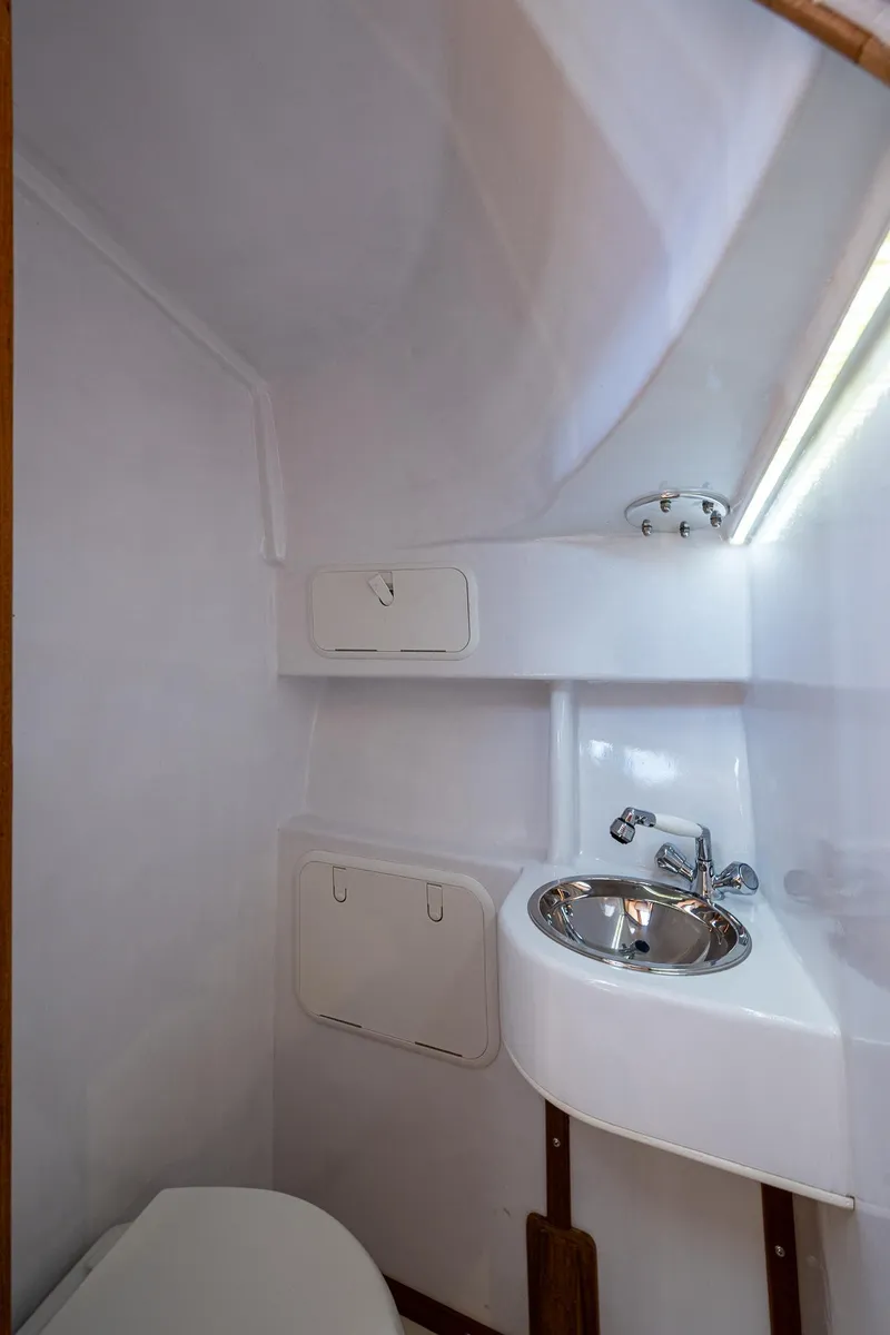 Slide: The Image of 2019 Custom Carolina Custom Express boat bathroom with compact sink and storage. - 21