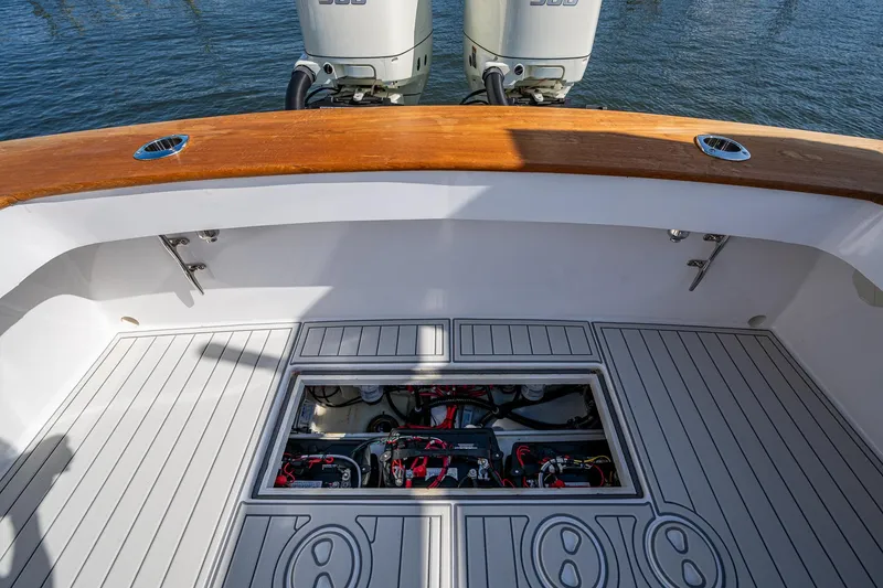Slide: The Image of 2019 Custom Carolina Custom Express boat deck with open hatch, revealing engine components. - 25