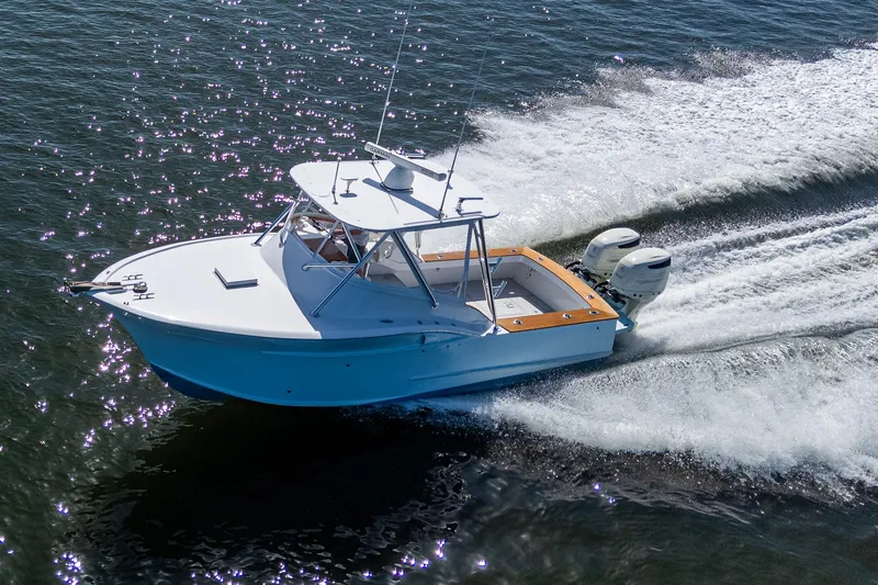 Slide: The Image of 2019 Custom Carolina Custom Express boat cruising on open water, creating a dynamic wake. - 3