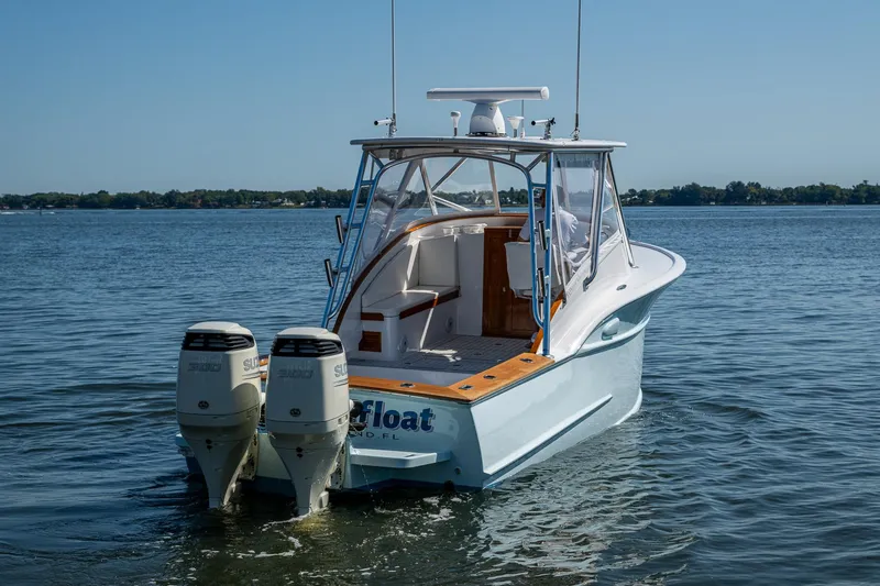 Slide: The Image of 2019 Custom Carolina Custom Express boat with dual engines on calm water. - 31