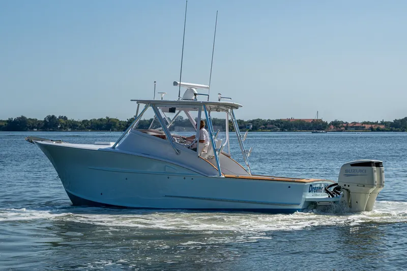 Slide: The Image of 2019 Custom Carolina Custom Express boat cruising on a calm lake. - 32