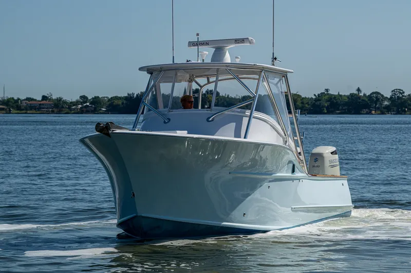 Slide: The Image of 2019 Custom Carolina Custom Express boat cruising on calm waters. - 36