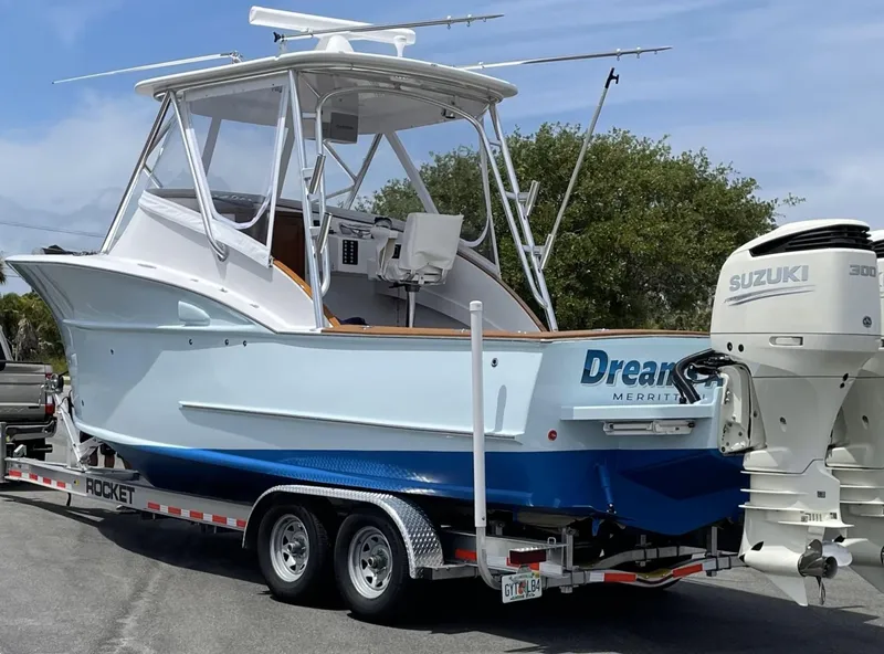 Slide: The Image of 2019 Custom Carolina Express boat on trailer with Suzuki 300 engine, parked outdoors. - 43