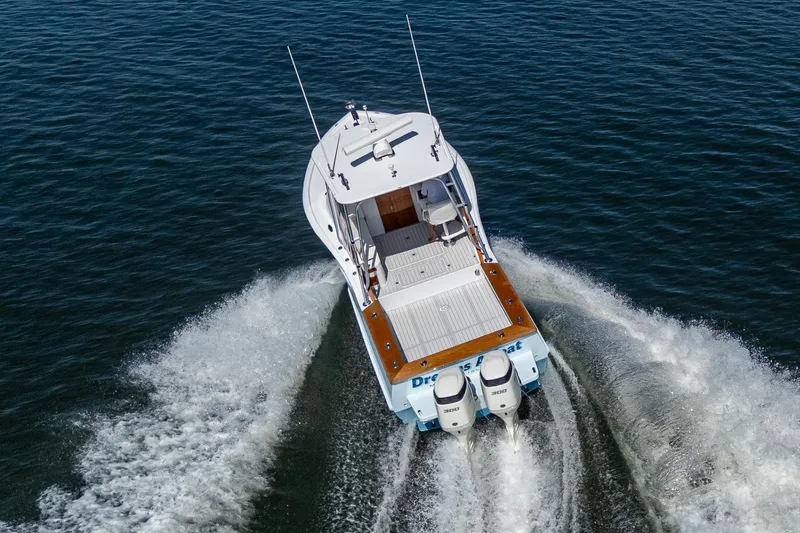 Slide: The Image of 2019 Custom Carolina Custom Express boat cruising on open water, rear view. - 8