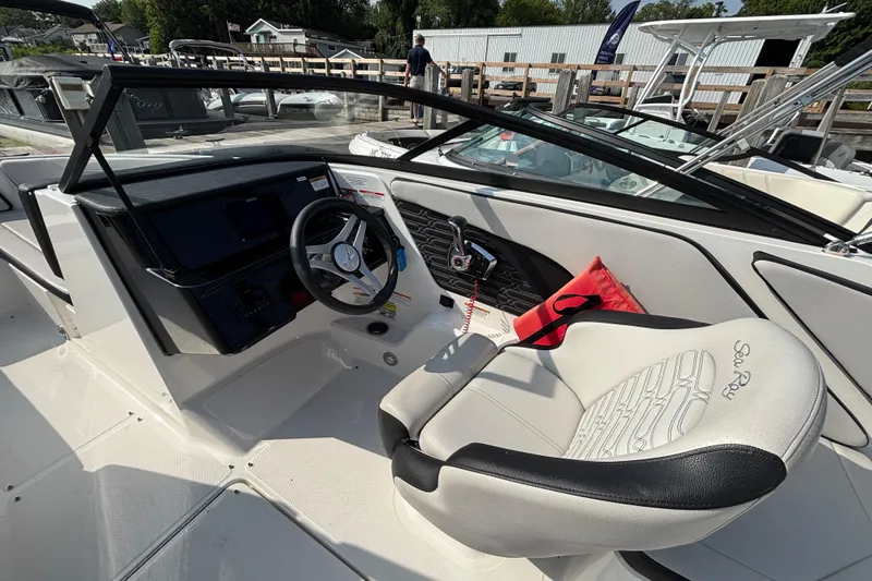 Slide: The Image of 2024 Sea Ray SPX 210 Outboard boat interior with steering wheel and seating. - 4