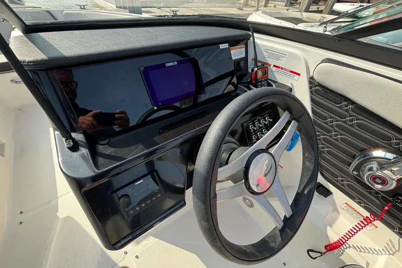 Slide: The Image of 2024 Sea Ray SPX 210 Outboard dashboard with steering wheel and control panel. - 5