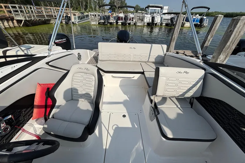 Slide: The Image of 2024 Sea Ray SPX 210 Outboard boat interior with seating and dock view. - 6