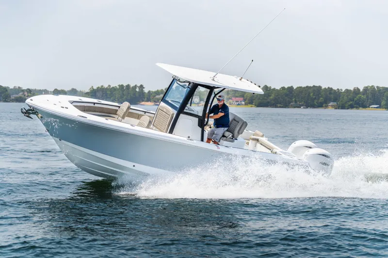 Slide: The Image of 2026 Sea Hunt Gamefish 25 cruising on a lake with a person at the helm. - 25