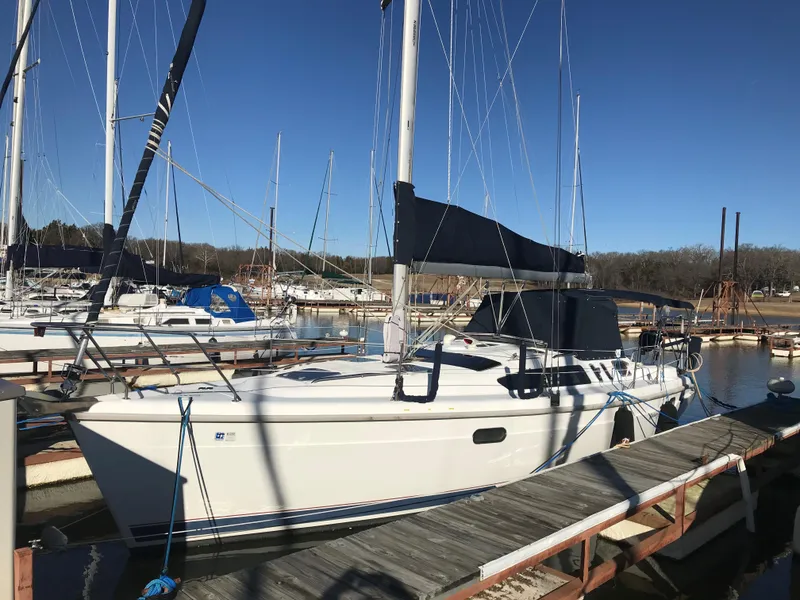 The Image of 1997 Hunter 376 sailboat on stands, named "Holiday Dreamin'," with blue sky background. - 0