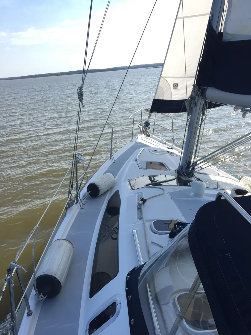 Slide: The Image of 1997 Hunter 376 sailboat docked at marina, featuring sleek design and covered cockpit. - 11