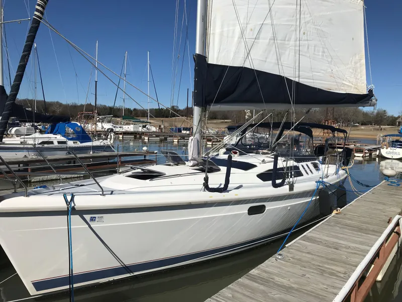 Slide: The Image of 1997 Hunter 376 sailboat docked at marina, featuring sleek white design and black sail cover. - 3