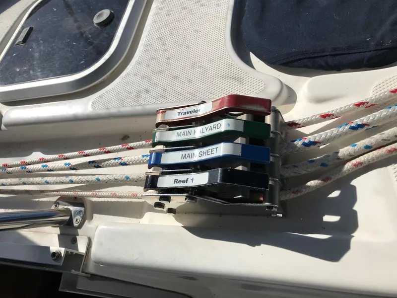 Slide: The Image of 1997 Hunter 376 yacht interior with blue bedding, striped pillow, and wooden cabinetry. - 31