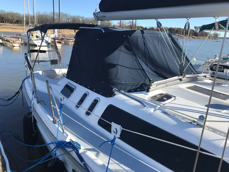 Slide: The Image of 1997 Hunter 376 sailboat docked at marina, featuring sleek design and covered cockpit. - 4