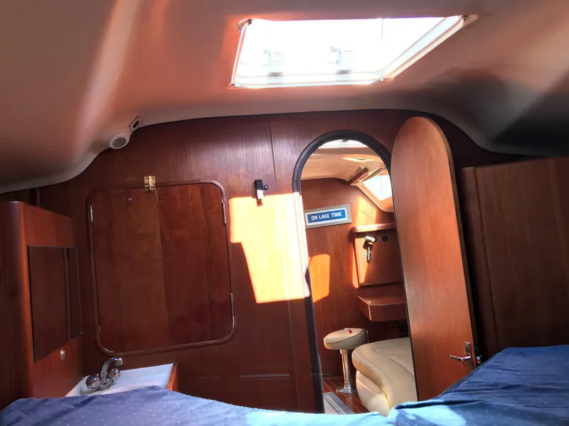 Slide: The Image of Interior cabin of a 1997 Hunter 376 sailboat with a spacious bed and wooden flooring. - 43