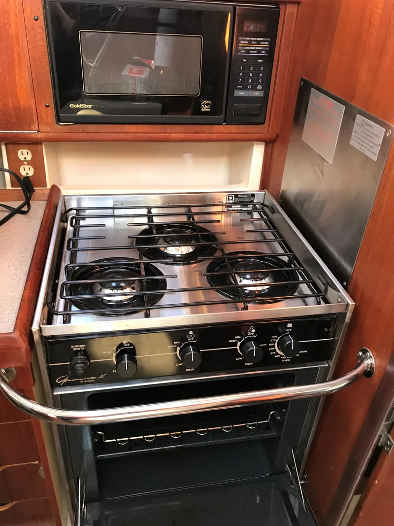 Slide: The Image of Interior of a 1997 Hunter 376 sailboat with wooden cabinetry and kitchen amenities. - 45