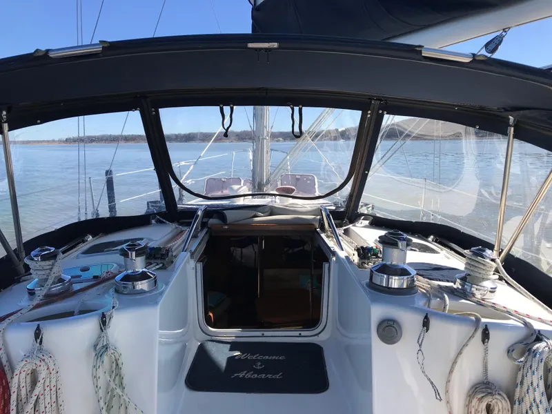 Slide: The Image of 1997 Hunter 376 sailboat docked at marina, featuring sleek design and covered cockpit. - 6