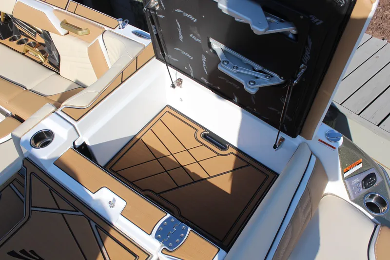 Slide: The Image of 2026 Tigé Ultré 25ZX boat interior with open storage compartment and luxurious seating. - 10