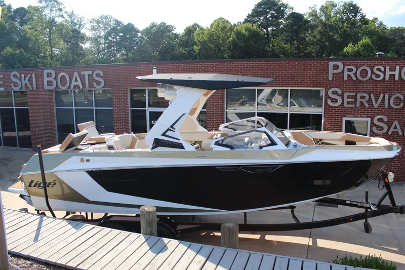 Slide: The Image of 2026 Tigé Ultré 25ZX boat displayed at a dealership, showcasing sleek design. - 12