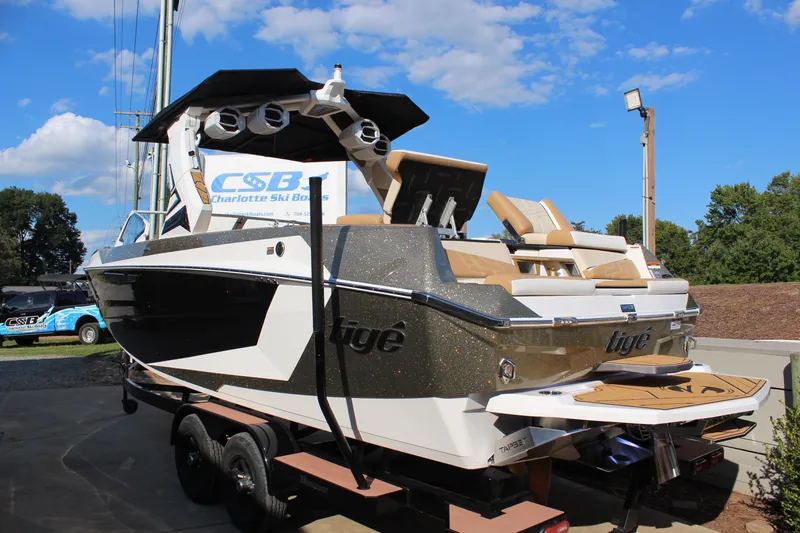 Slide: The Image of 2026 Tigé Ultré 25ZX boat with sleek design, parked outdoors under blue sky. - 15