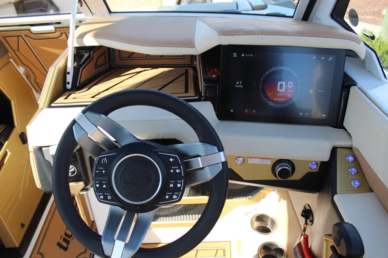 Slide: The Image of 2026 Tigé Ultré 25ZX boat dashboard with modern steering wheel and touchscreen display. - 2