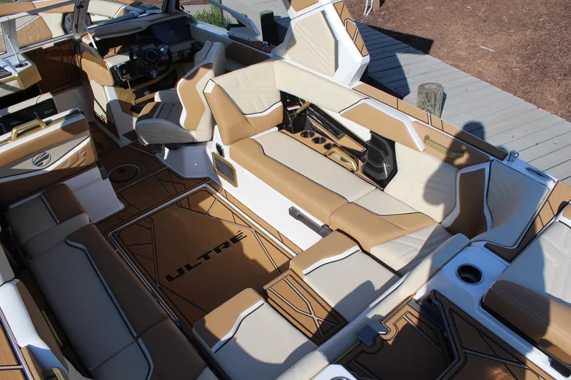 Slide: The Image of 2026 Tigé Ultré 25ZX boat interior with tan and white seating, modern dashboard, and stylish design. - 27