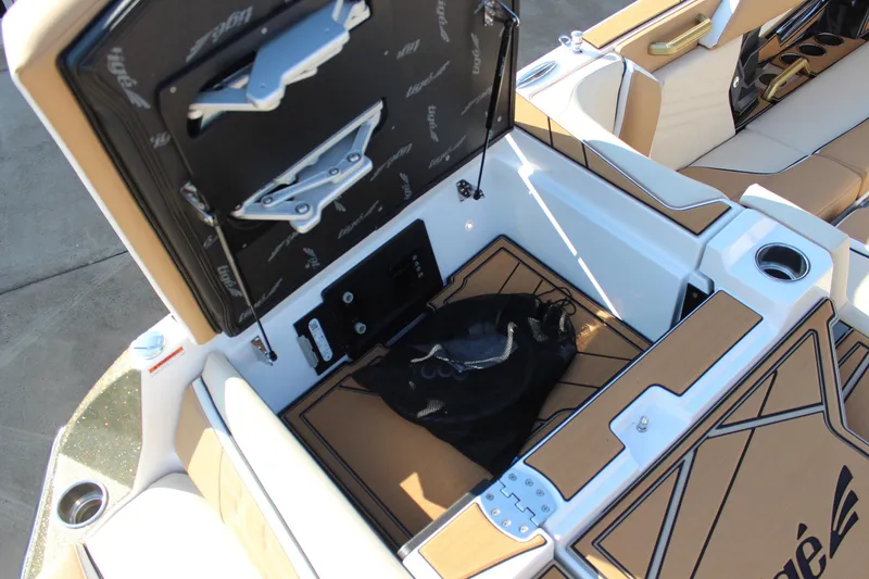 Slide: The Image of 2026 Tigé Ultré 25ZX boat interior with open storage compartment and luxury seating. - 9