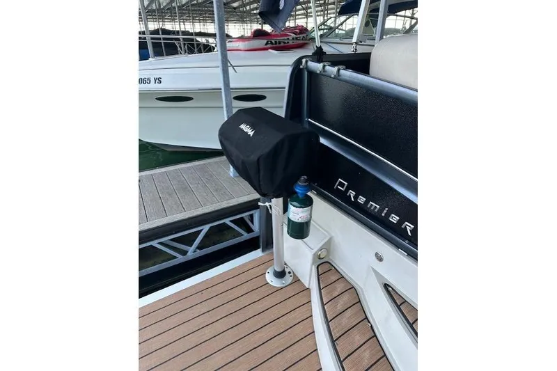 Slide: The Image of 2019 Premier 290 Grand View boat with covered grill and docked at marina. - 13