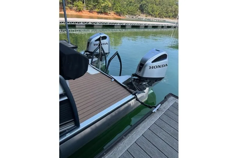 Slide: The Image of 2019 Premier 290 Grand View boat with dual Honda outboard motors docked on calm water. - 15