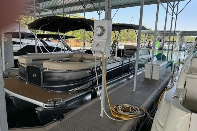 Slide: The Image of 2019 Premier 290 Grand View pontoon boat docked at marina under covered slip. - 17