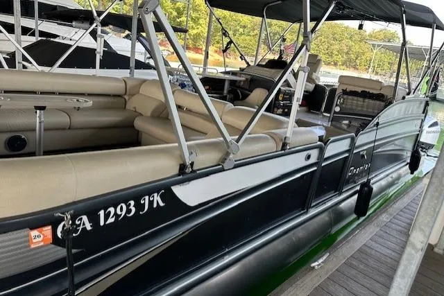 Slide: The Image of 2019 Premier 290 Grand View pontoon boat docked, featuring beige seating and canopy. - 18