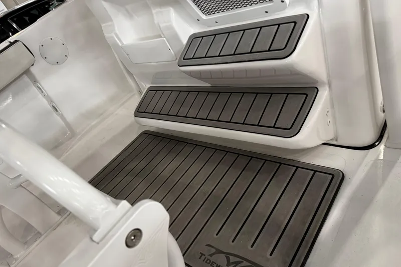 Slide: The Image of 2026 Tidewater 198 CC Adventure boat seating with black and white upholstery in a showroom. - 12