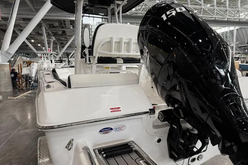 Slide: The Image of 2026 Tidewater 198 CC Adventure boat interior with T-top and seating in a showroom. - 6