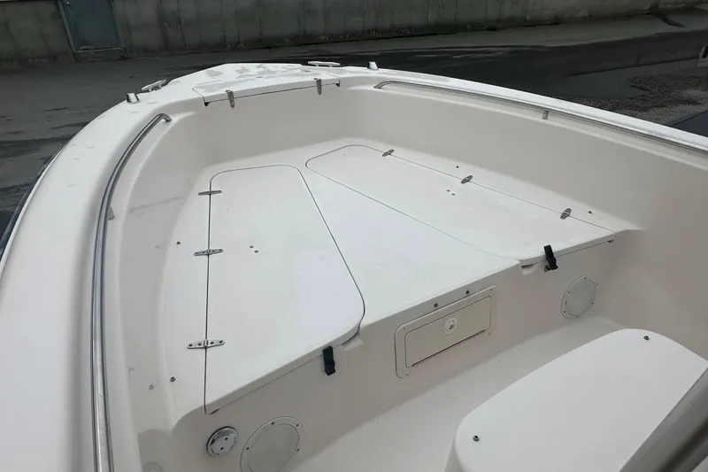 Slide: The Image of 2000 Grady-White Advance 247 boat interior, featuring spacious white deck and storage compartments. - 6