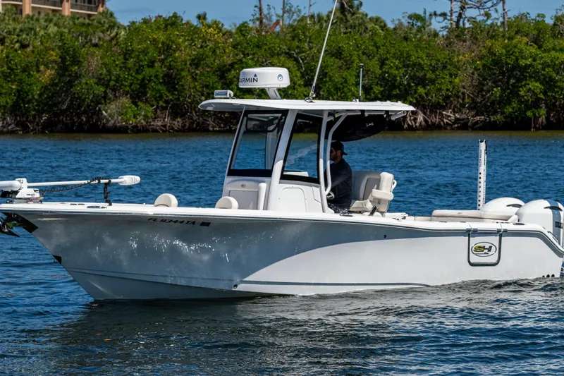 The Image of 2022 Sea Hunt Ultra 265 SE boat cruising on a calm waterway. - 0