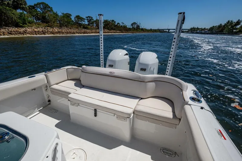 Slide: The Image of 2022 Sea Hunt Ultra 265 SE boat interior with seating and twin engines on a sunny day. - 10