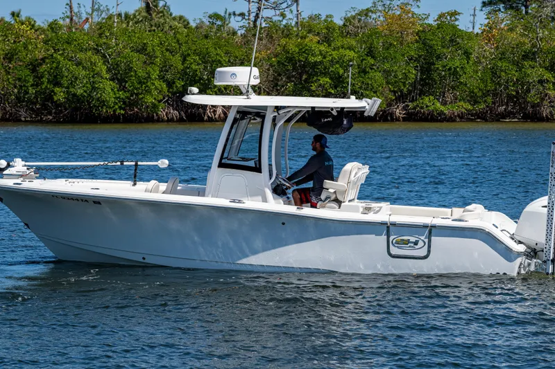 Slide: The Image of 2022 Sea Hunt Ultra 265 SE boat cruising on a calm waterway. - 14