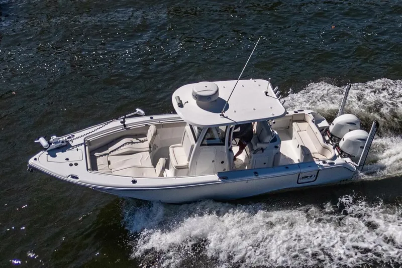 Slide: The Image of 2022 Sea Hunt Ultra 265 SE boat cruising on water, showcasing sleek design and dual engines. - 17